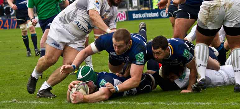 Rugby players dive for the ball. Image Credit: Tony McIntyre, via Flickr/CC.